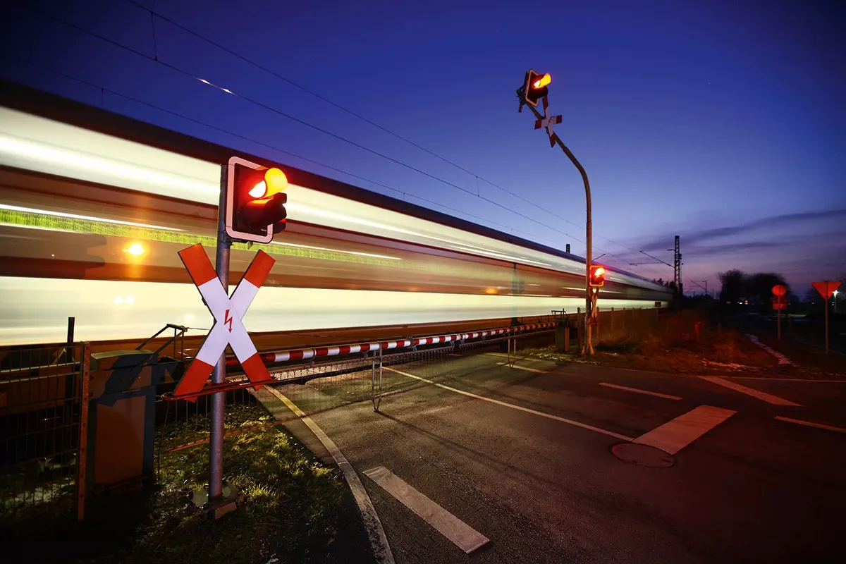 level crossing with train passing at night