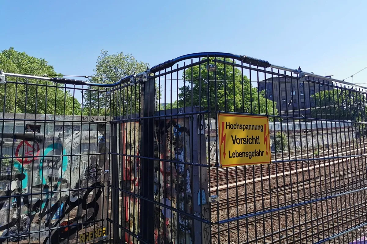 Fenced-off railway area with a sign reading ‘High voltage – danger to life’
